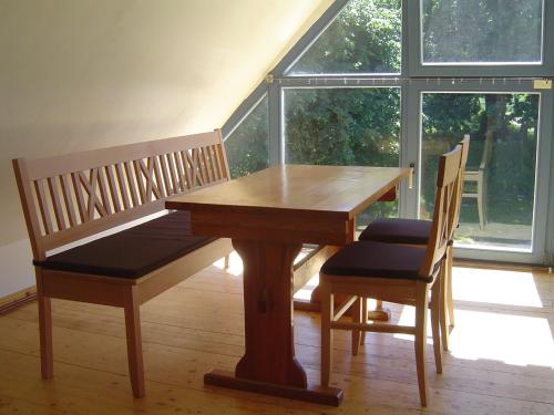 a wooden table with two chairs and a wooden table and bench at Zum Schwarzen Stiefel- Ferienwohnung Atelierhaus in Liepe