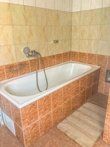a bath tub with a shower in a bathroom at Apartaments Ogre. in Ogre
