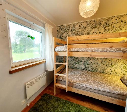 1 dormitorio con 2 literas y ventana en Kalda Holiday Home, en Otepää