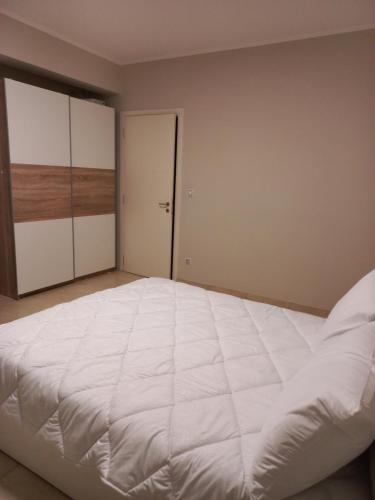 1 dormitorio con 1 cama blanca grande y armario en Grand Afroditi LUX en Pýrgos