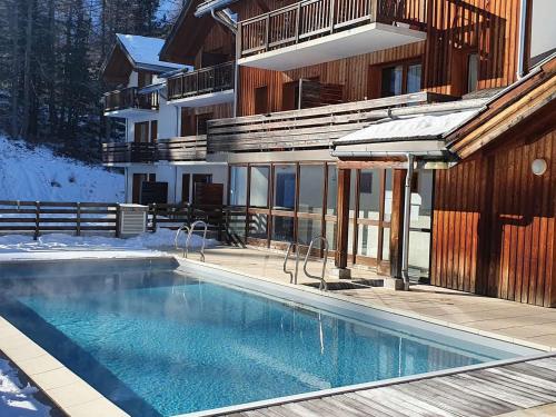 une piscine devant un immeuble dans l'établissement Chalet de standing avec piscine, sauna et hammam - 6/7 pers, au pied des pistes Les Orres 1800 - FR-1-322-434, aux Orres