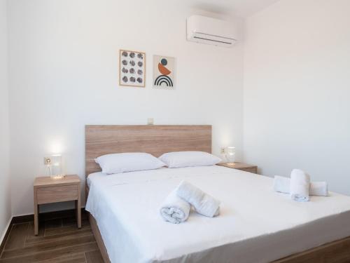 a bedroom with a bed with white sheets and towels at Apartment Santa Marina 4 in Asgourou