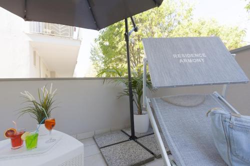 a table and an umbrella on a balcony at Residence Armony in Misano Adriatico
