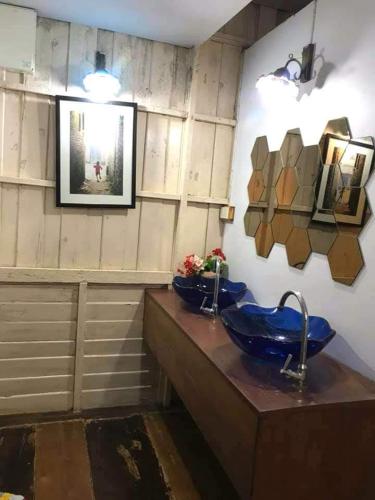 a bathroom with two sinks and a picture on the wall at นิทานคำกลอน 2 Nithankumkon 2 in Amphawa