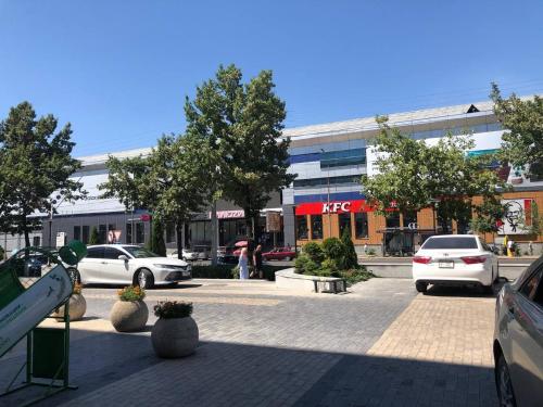 a parking lot with cars parked in front of a building at Downtown Homestay in Bishkek