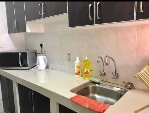 a kitchen counter with a sink and a microwave at Homestay Tok Wan Puchong Utama in Puchong