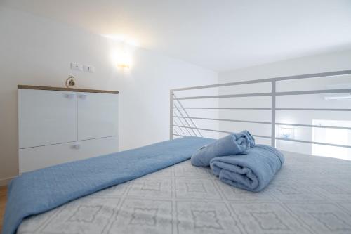 ein Schlafzimmer mit einem Bett mit einer blauen Decke darauf in der Unterkunft Angolo del Sole in Villanova di Ostuni