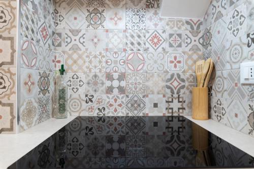 a kitchen with tiles on the wall and a counter at Angolo del Sole in Villanova di Ostuni