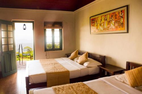 a hotel room with two beds and a window at Sir John's Bungalow in Matale