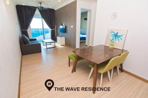 a dining room and living room with a table and chairs at Cardamom The Wave&Atlantis Residence Melaka Town in Malacca