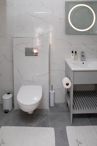 a white bathroom with a toilet and a sink at Day's End Guest House in East London