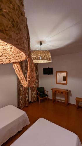 a bedroom with a bed and a table and a mirror at Hotel de Montaña La Hortizuela in Coto Rios