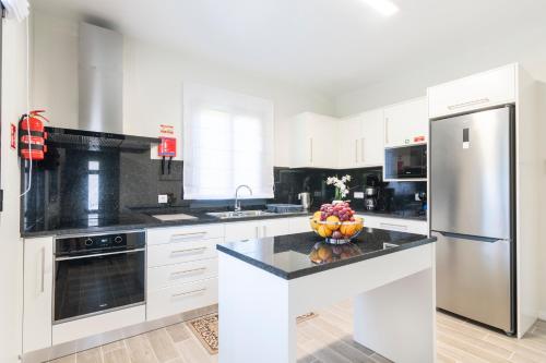 a kitchen with a refrigerator and a bowl of fruit on a counter at Villa Pearl in Santana