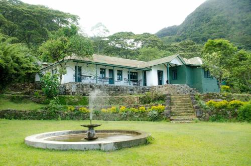 a house with a fountain in front of a yard at Sir John's Bungalow in Matale