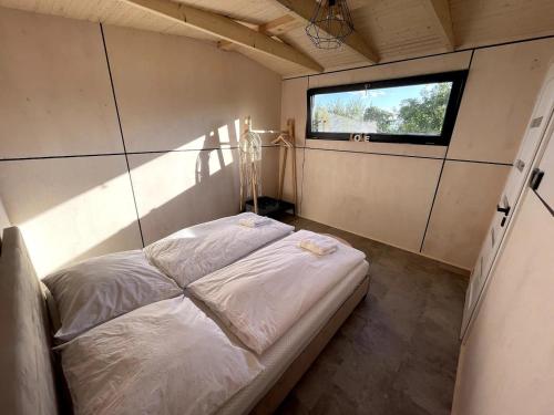 - un petit lit dans une chambre avec fenêtre dans l'établissement Moderné ubytovanie so saunou na liptovskom vidieku, à Liptovské Matiašovce