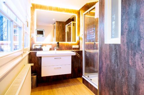 a bathroom with a sink and a shower at Hotel Villa Monte Vino in Potsdam