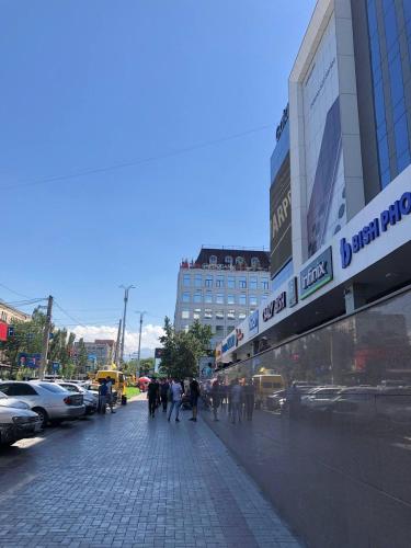 a group of people walking down a sidewalk in a city at Downtown Homestay in Bishkek