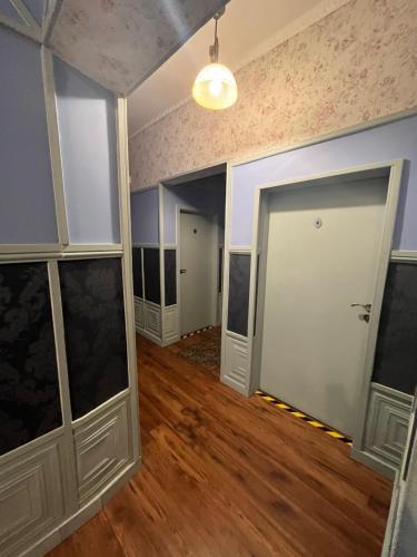 pusty pokój z białymi drzwiami i drewnianą podłogą w obiekcie Pałac Victoria w mieście Mgowo