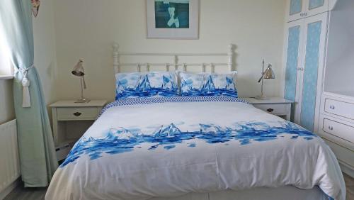 米爾敦馬爾貝的住宿－Southland Holiday Home，一间卧室配有蓝色和白色床单