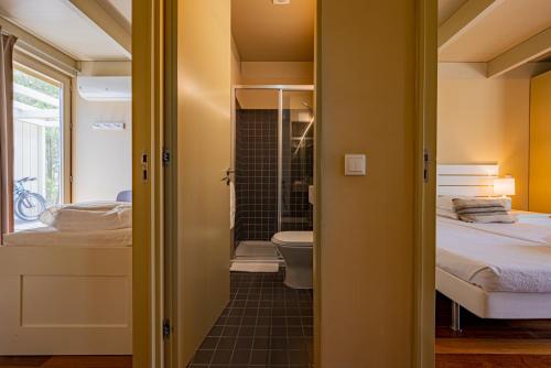 a small bathroom with a bed and a toilet at Pestana Troia Eco-Resort & Residences in Troia