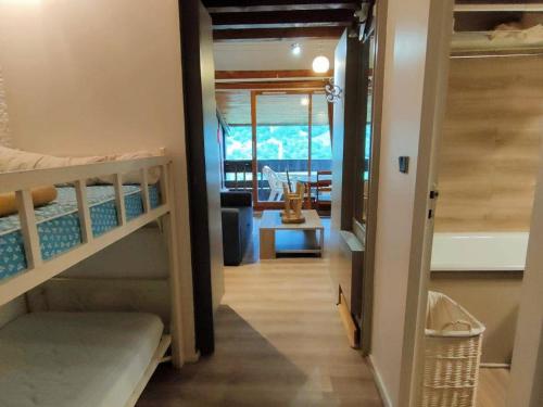 un couloir menant à une chambre avec des lits superposés dans l'établissement Appartement T1bis 4-6 pers avec Terrasse et Parking à Cauterets - FR-1-234-238, à Cauterets