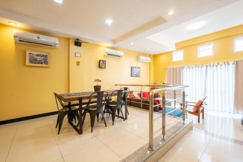 a dining room with yellow walls and a table and chairs at Casa Heradurra Uno/Dos in Manila