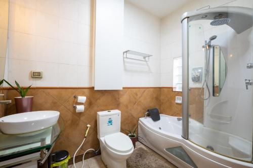 a bathroom with a toilet and a tub and a sink at Casa Heradurra Uno/Dos in Manila