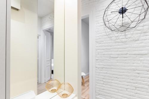 Pokój z białą ceglaną ścianą i lustrem w obiekcie Canela Homes BARCELONA MARINA w Barcelonie