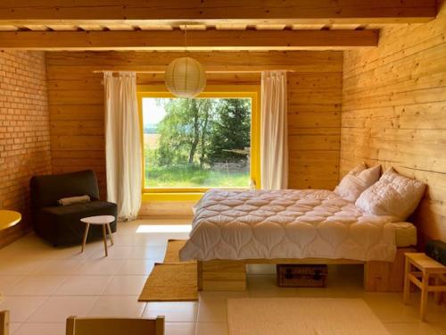 ein Schlafzimmer mit einem Bett und einem großen Fenster in der Unterkunft Penzion Výhledy na Brdy in Těškov
