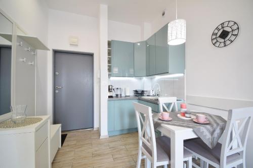 a kitchen and dining room with a table and chairs at Apartament Rafa Koralowa in Dziwnówek
