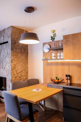 a kitchen and dining room with a wooden table at Apartman NISA - Ovruč in Štrbské Pleso