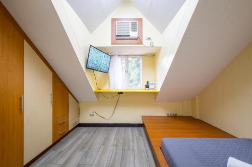 an attic bedroom with a bed and a window at Casa Heradurra Uno/Dos in Manila