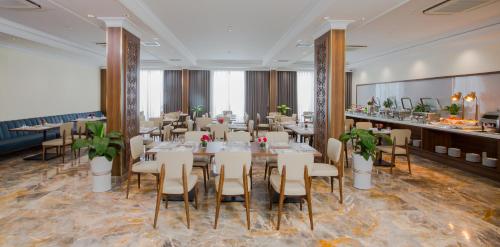 a restaurant with tables and chairs in a room at PHU THANG GRAND HOTEL in Ðức Hòa