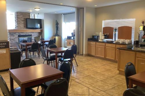 a restaurant with tables and chairs and a fireplace at Baymont Inn & Suites by Wyndham Holbrook in Holbrook