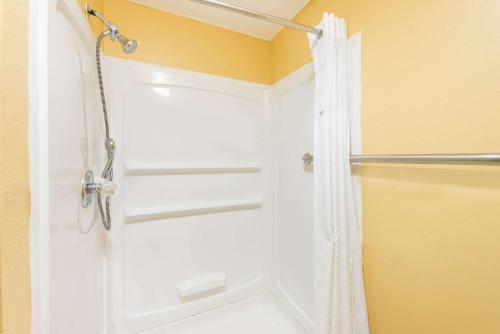y baño con ducha y puerta blanca. en Super 8 by Wyndham Okawville, en Okawville