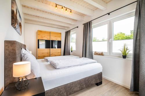 um quarto com uma cama grande e uma janela em NordseeResort Büsum Ferienhaus 63 Küstenlodge em Büsum