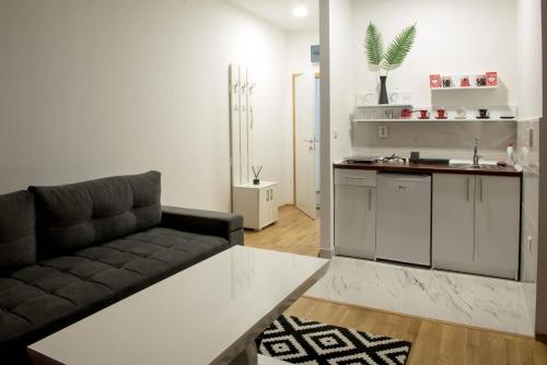 a living room with a couch and a kitchen at Apartmani Pijemont in Višegrad