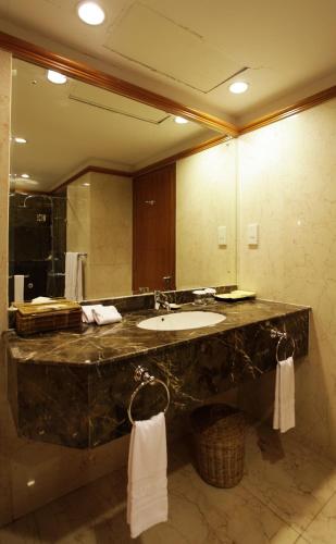 a bathroom with a sink and a large mirror at Muong Thanh Holiday Da Lat Hotel in Da Lat