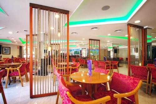 a restaurant with wooden tables and red chairs at Hotel Servigroup Castilla in Benidorm