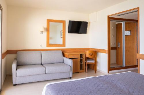 a hotel room with a couch and a mirror at htop Pineda Palace 4Sup - Adults Recommended #htopBliss in Pineda de Mar