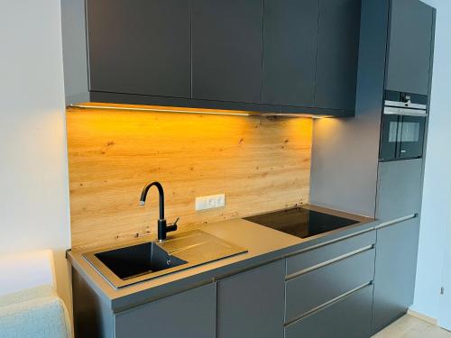 a kitchen with a sink and a refrigerator at Das Taja Paznaun Penthouse Apartments in See