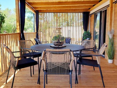 a patio with a table and chairs on a deck at Mobile Home Mar Vista Selce in Selce