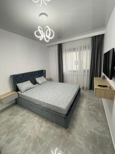 a bedroom with a bed and a chandelier at Near Sea Apart Mamaia Nord in Mamaia Nord
