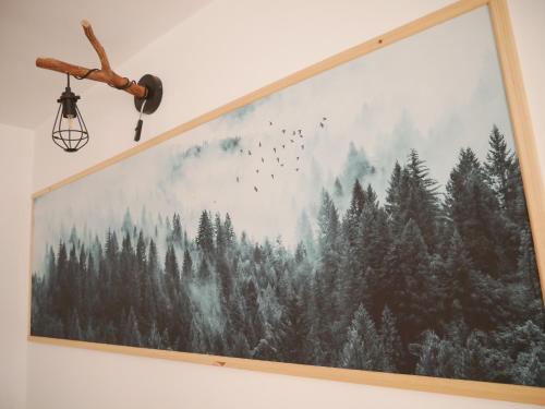 a large picture hanging on a wall with trees and birds at Przystanek Srebrna Góra in Srebrna Góra
