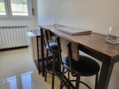 - une table en bois avec deux chaises et un ordinateur portable dans l'établissement DayDreaming - 5 min Stazione Centrale, à Bologne