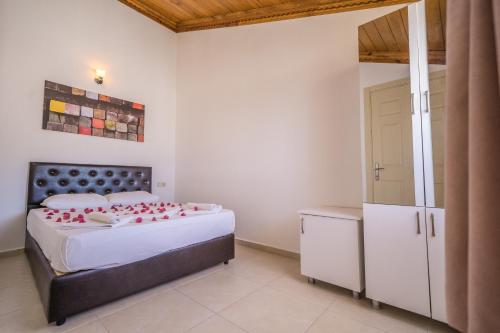 a bedroom with a bed with red roses on it at Karia Apart&Pension in Mesudiye