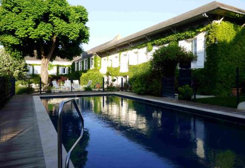 - une piscine en face d'une maison dans l'établissement Logis Hôtel La Tonnellerie, à Beaugency