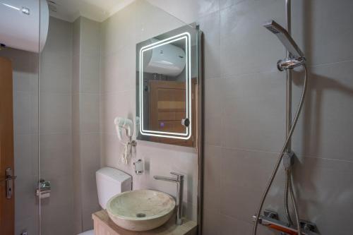 a bathroom with a sink and a shower with a mirror at Monte Pino Lux Apartments in Žabljak