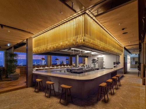 a restaurant with a bar with bar stools at b'mine Hotel Frankfurt Airport in Frankfurt/Main