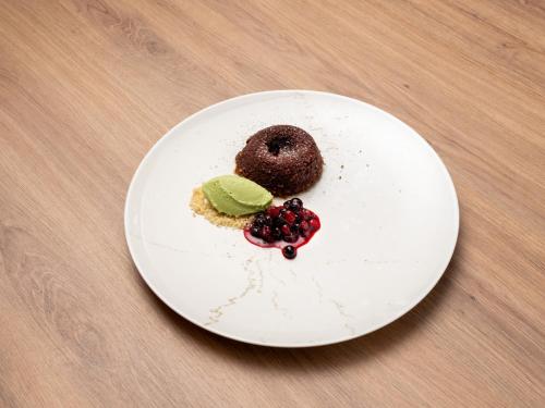 a white plate with a chocolate donut on a table at b'mine Hotel Frankfurt Airport in Frankfurt/Main